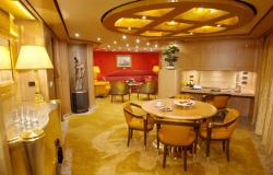 MS Oosterdam - Holland America Line - Interiér luxusního apartmánu s jídelním stolem a minibarem