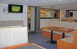 Spirit of Enderby - Polar Cruises - lodní knihovna se stoly, TV a obslužným barem