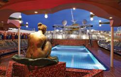 Costa Magica - Costa Cruises - bronzová nymfa a bazén na horní palubě v noci